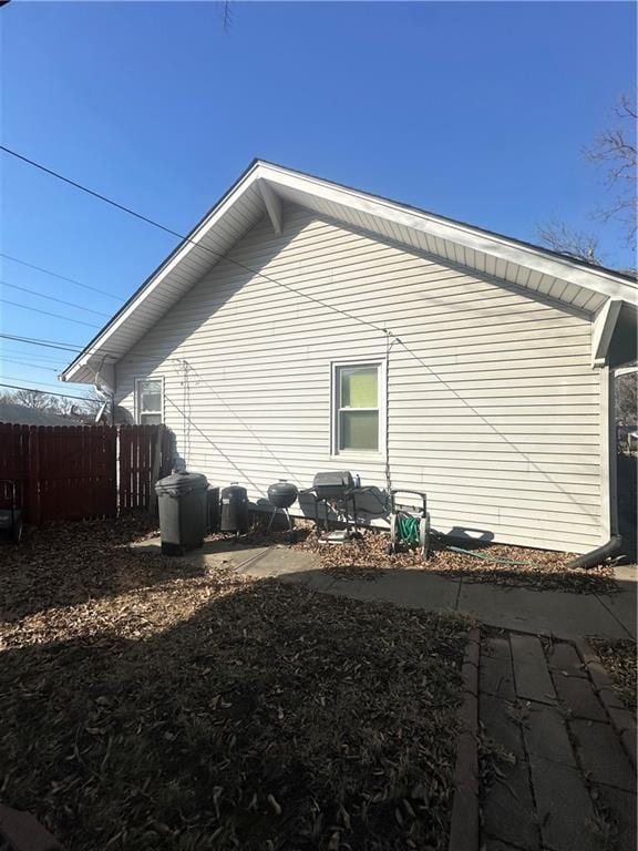 view of side of home featuring fence