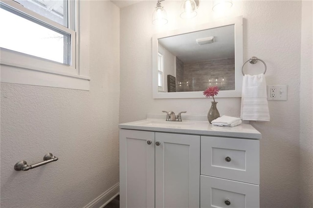 bathroom with a textured wall and vanity