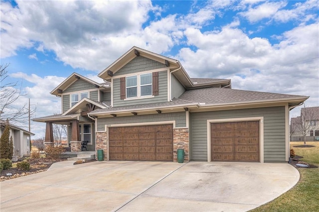 craftsman-style house featuring driveway, stone siding, and an attached garage