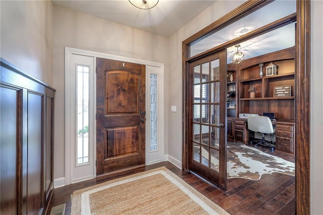 entryway featuring wood finished floors, visible vents, and baseboards