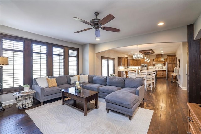 living room featuring a ceiling fan, recessed lighting, dark wood finished floors, and baseboards