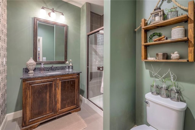 bathroom with a stall shower, vanity, toilet, and tile patterned floors