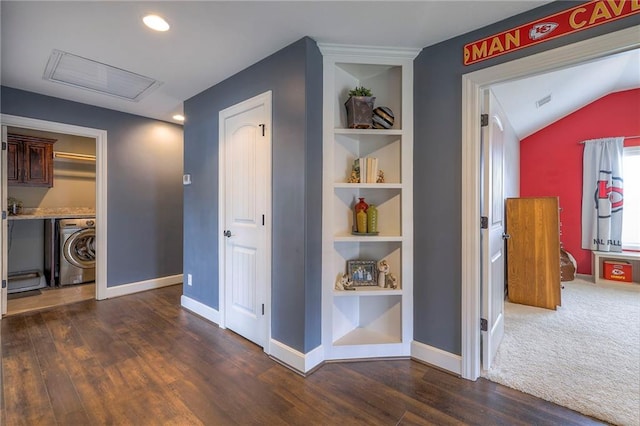 hall featuring built in shelves, dark wood-type flooring, washer / dryer, baseboards, and attic access