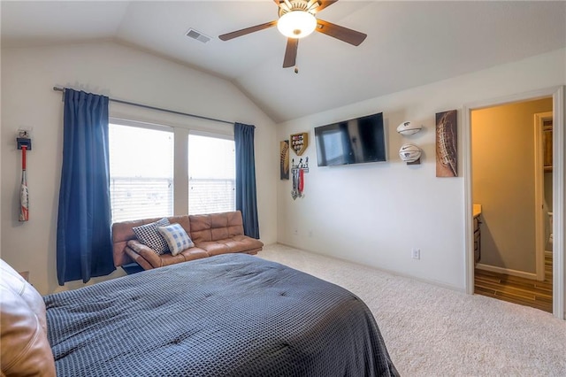 carpeted bedroom featuring lofted ceiling, visible vents, and a ceiling fan