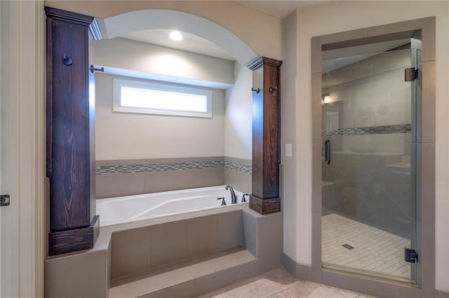 bathroom with a stall shower, a garden tub, and tile patterned floors