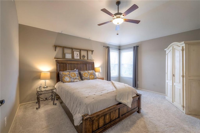 carpeted bedroom with ceiling fan and baseboards