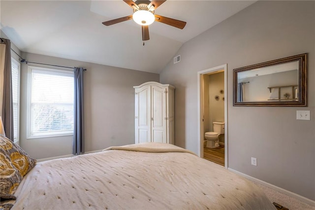 unfurnished bedroom featuring ceiling fan, connected bathroom, visible vents, baseboards, and vaulted ceiling