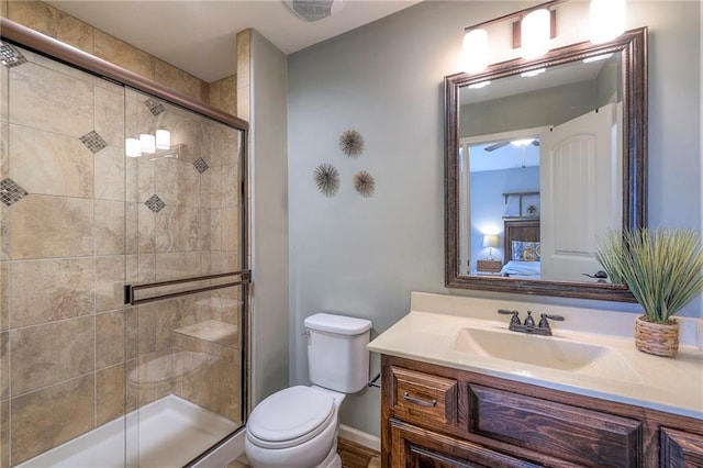 bathroom featuring baseboards, vanity, toilet, and a shower stall