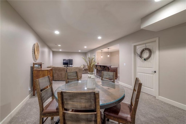 dining room featuring light carpet, baseboards, and recessed lighting