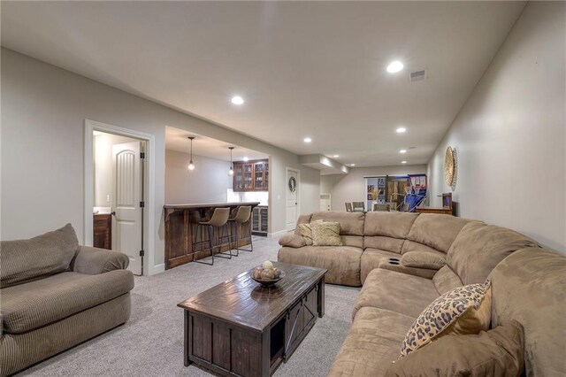 living area with recessed lighting, light carpet, bar area, visible vents, and baseboards