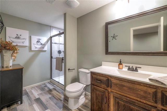 full bath featuring toilet, a shower stall, wood finished floors, and vanity