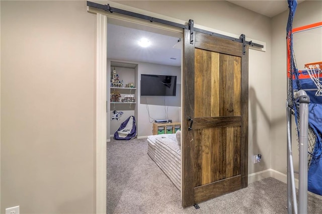 interior space with a barn door, carpet, and baseboards