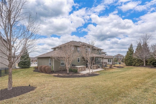 rear view of property featuring a yard, a patio area, and fence