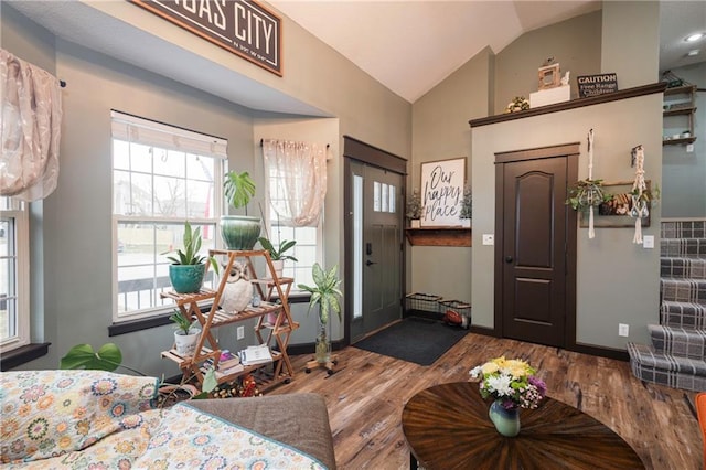 foyer with wood finished floors, baseboards, and vaulted ceiling