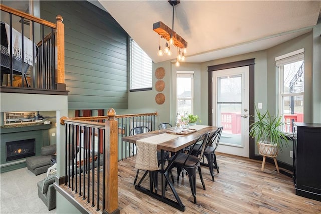 dining room with wood finished floors and a warm lit fireplace