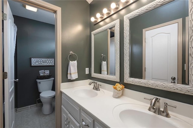 bathroom featuring a sink, toilet, double vanity, and tile patterned flooring