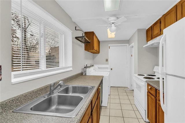 kitchen featuring white appliances, brown cabinets, a sink, and under cabinet range hood