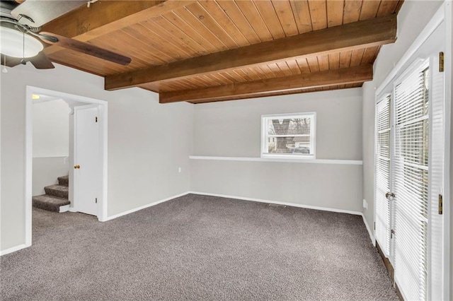 unfurnished bedroom featuring wood ceiling, multiple windows, beamed ceiling, and baseboards