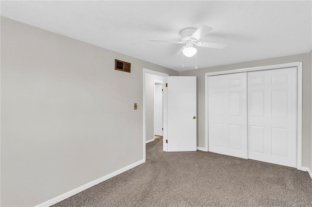 unfurnished bedroom featuring baseboards, a ceiling fan, carpet flooring, a textured ceiling, and a closet