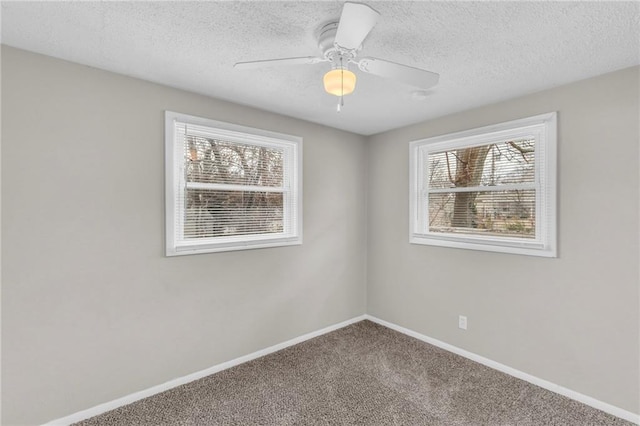 carpeted spare room featuring a textured ceiling, a ceiling fan, and baseboards