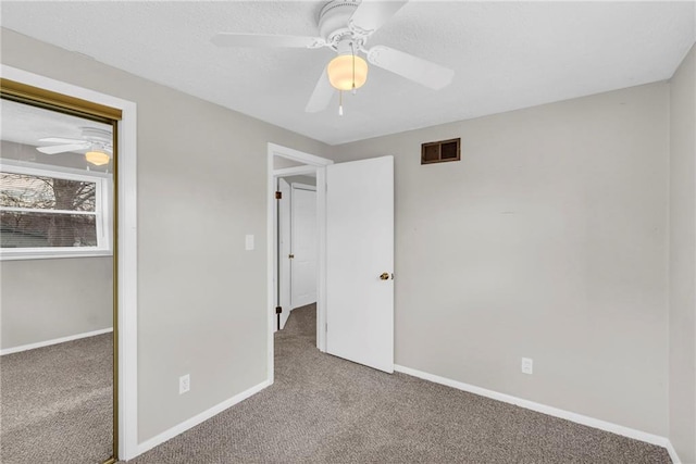 unfurnished bedroom with carpet, a closet, visible vents, and baseboards