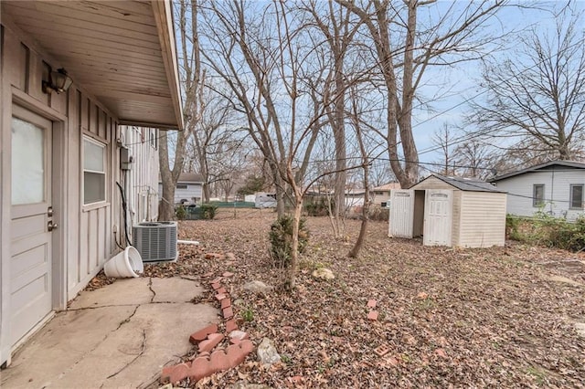 view of yard with an outdoor structure, fence, a storage shed, and central air condition unit