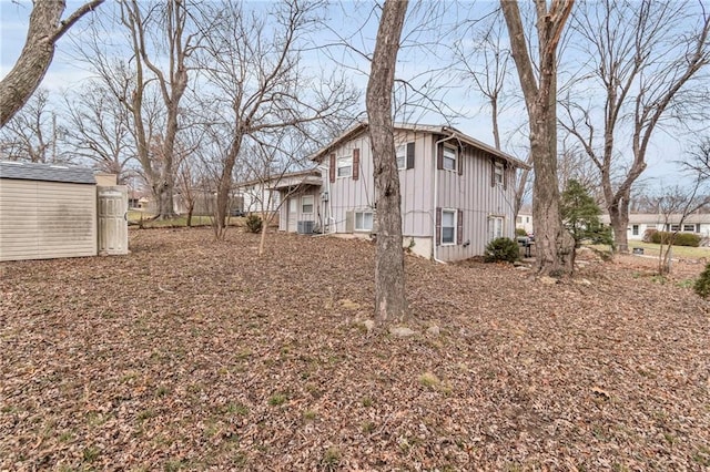 view of home's exterior with board and batten siding, an outdoor structure, and a storage unit