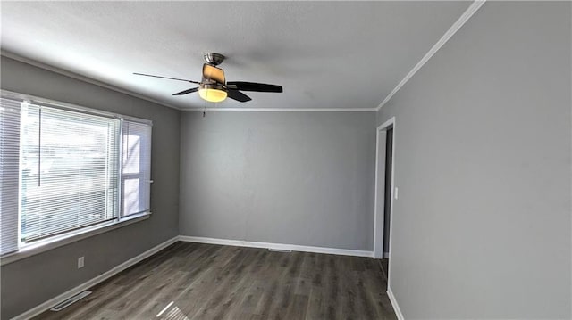 empty room featuring ornamental molding, wood finished floors, visible vents, and baseboards