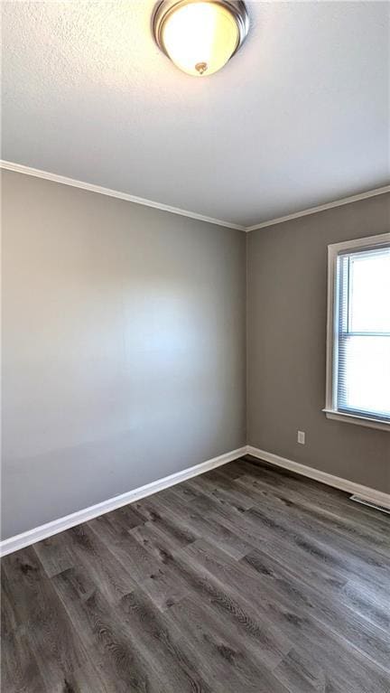 unfurnished room featuring dark wood-style floors, crown molding, and baseboards