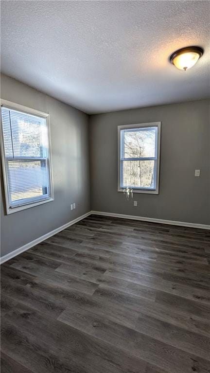 unfurnished room with dark wood finished floors and a textured ceiling