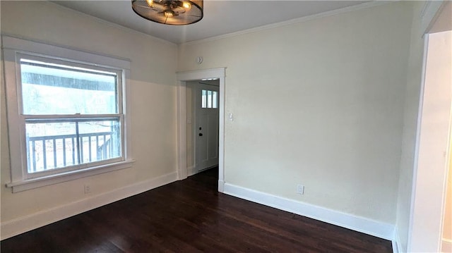 unfurnished room featuring crown molding, dark wood-type flooring, and baseboards