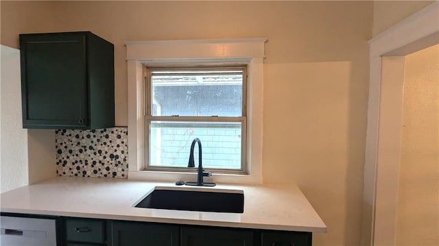 kitchen featuring light countertops, a sink, and dark cabinets