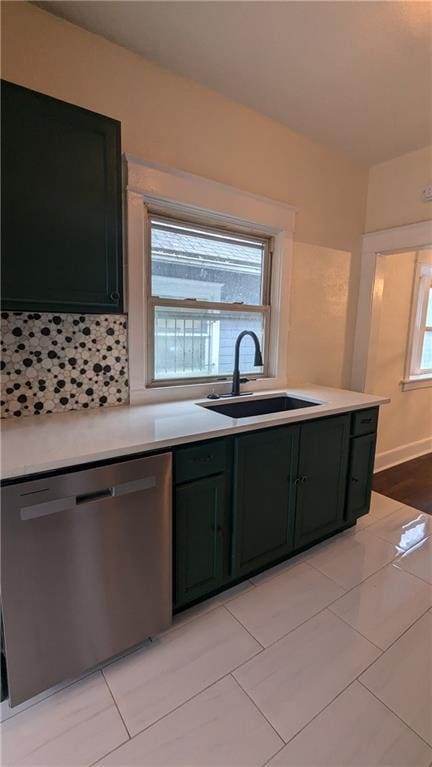 kitchen with tasteful backsplash, light countertops, a sink, and stainless steel dishwasher