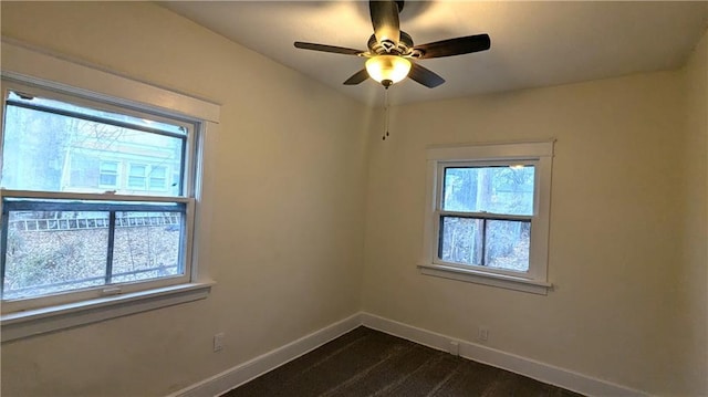 empty room with a ceiling fan and baseboards