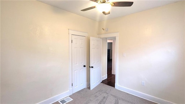 unfurnished bedroom featuring carpet floors, baseboards, visible vents, and a ceiling fan