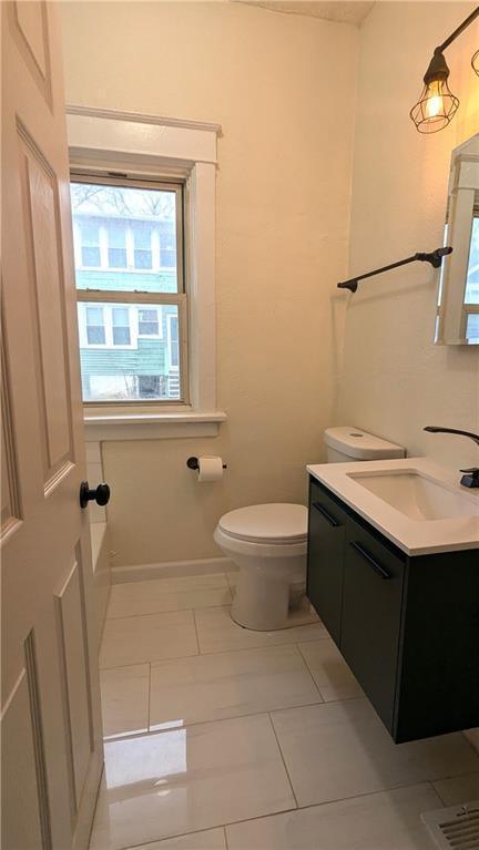 bathroom with baseboards, vanity, and toilet