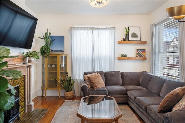 living area featuring wood-type flooring and a fireplace with flush hearth