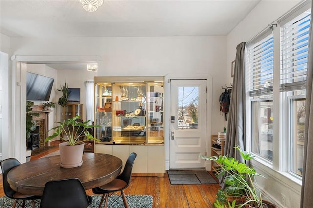 dining room with a fireplace and hardwood / wood-style floors