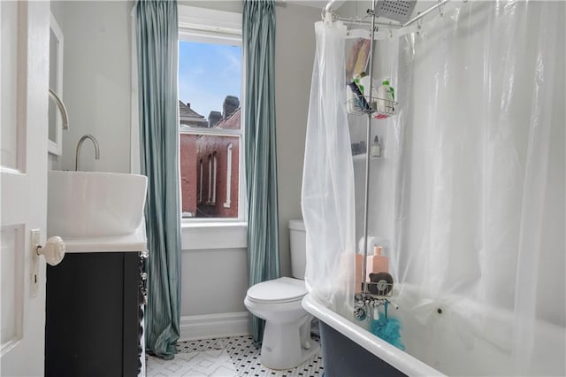 bathroom with shower / bath combination with curtain, baseboards, vanity, and toilet