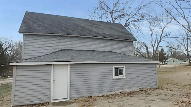 view of property exterior with roof with shingles