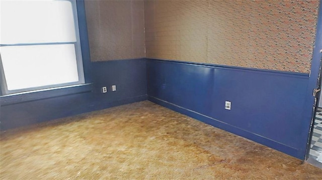 carpeted empty room with wainscoting