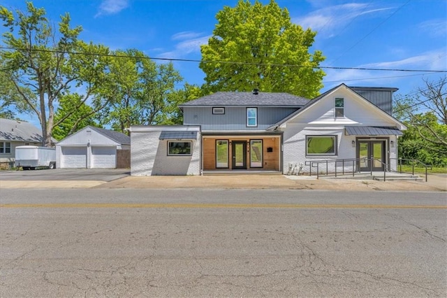 modern farmhouse style home with a detached garage and brick siding