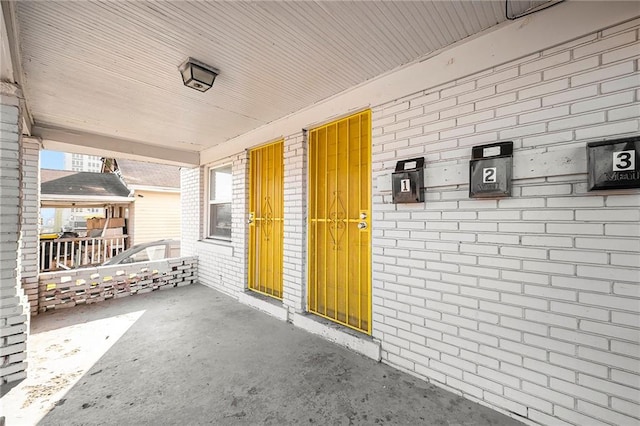 view of exterior entry featuring brick siding