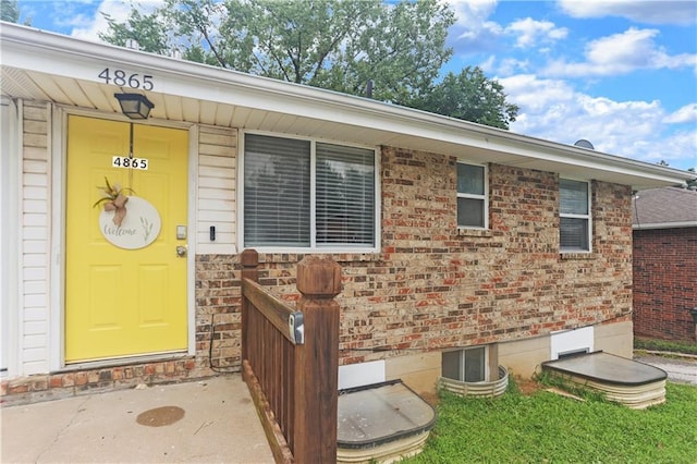 property entrance featuring brick siding