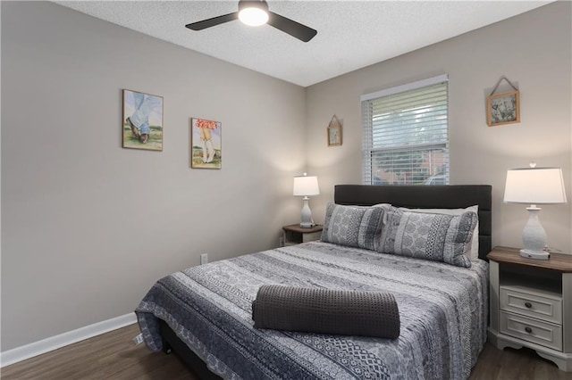 bedroom with a ceiling fan, wood finished floors, baseboards, and a textured ceiling