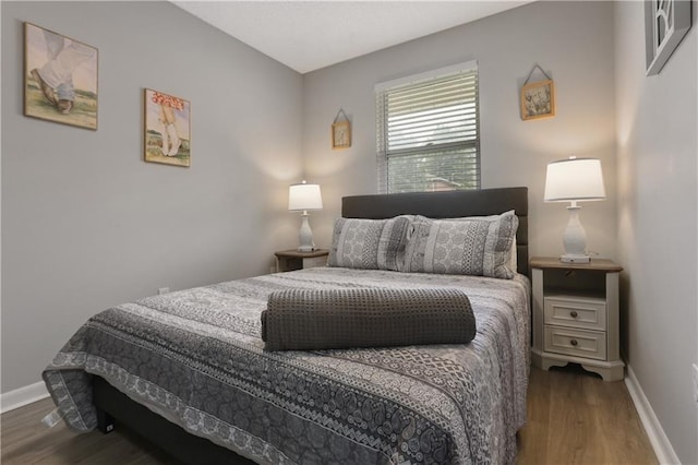 bedroom with baseboards and wood finished floors