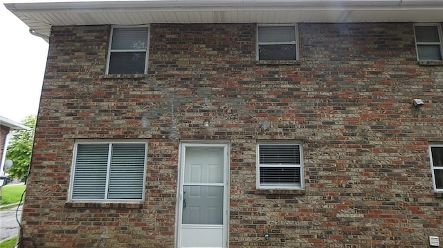 view of exterior entry with brick siding