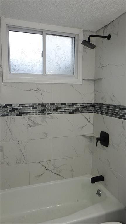 bathroom featuring a textured ceiling and bathtub / shower combination