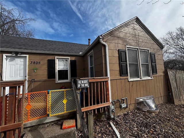 view of front of property with fence and roof with shingles