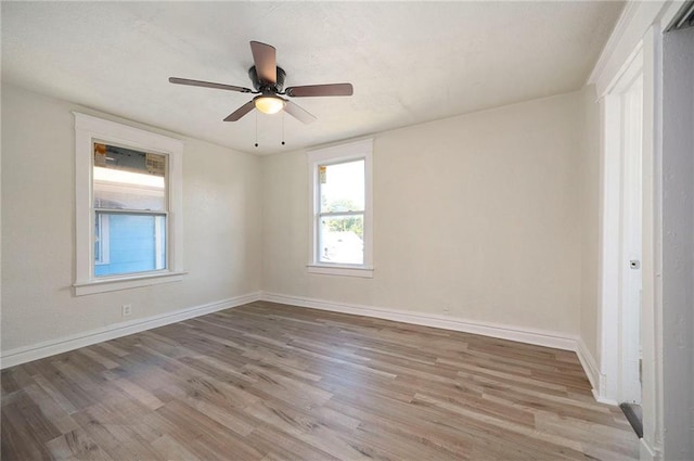 spare room with light wood-style flooring, baseboards, and ceiling fan